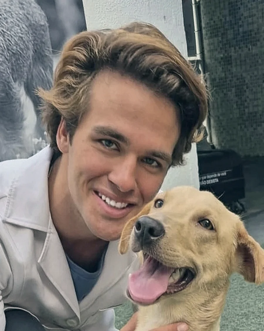 Mateus, cofundador da Viva Mais Bicho, agachado ao lado de um cachorro